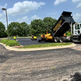 Smooth paving truck dumping material on to the asphalt for the project.