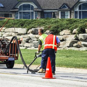 Smooth paving workers using a machine on the asphalt.