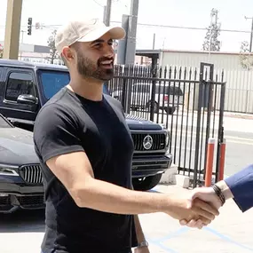 Fred the owner of LUXE Auto Body Shop shaking hands with customer