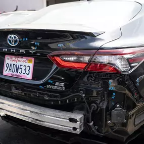 Detailed photo of Toyota Camry at auto body shop parking lot for collision repair