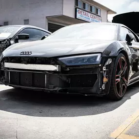 Detailed photo of Audi R8 waiting at auto body shop parking lot for collision repair