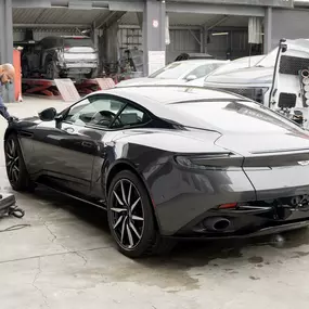 Detailed photo of Aston Martin at auto body shop parking lot after a successful collision repair