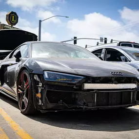 Detailed photo of Audi R8 waiting at auto body shop parking lot for collision repair