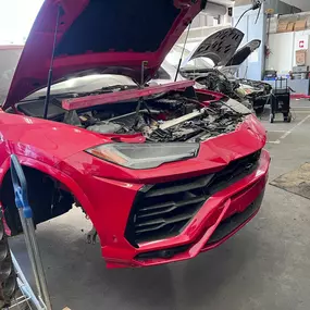 Detailed photo of Lamborghini Urus waiting at auto body shop parking lot for collision repair