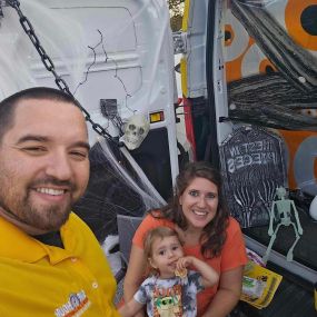 Jonathan & Heather Jacobs with their child, owners of One Hour Heating & Air Conditioning of Cockeysville, MD beside the company truck loaded with AC repair tools