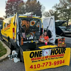 Heather Jacobs, owner of One Hour Heating & Air Conditioning of Cockeysville, MD at a trade fair sitting with the company truck loaded with AC repair tools