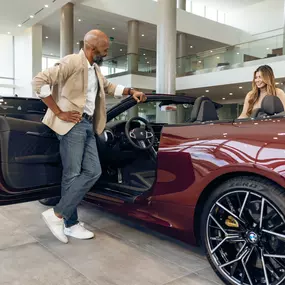 2 people admiring the Red BMW at BMW of Pembroke Pines