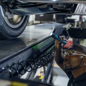 Service technician under a BMW at BMW of Pembroke Pines