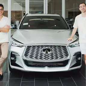 People standing in front of Holman INFINITI car