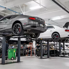 Vehicles up on lifts in a Holman Motorcars' service center