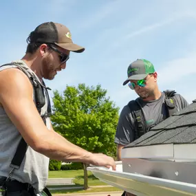 Larson & Keeney Contractors Installing a New Gutter System on a House