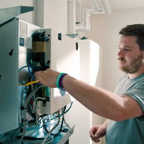 Installateur von 1KOMMA5° bei der Montage eines Stromspeichers in einem Keller