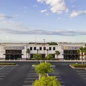 Exterior view of RTG Kids & Patio store with modern design and palm trees.