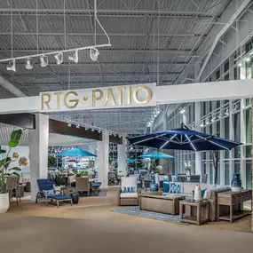 Patio furniture display at Rooms To Go Round Rock, TX, featuring stylish outdoor seating and umbrellas.