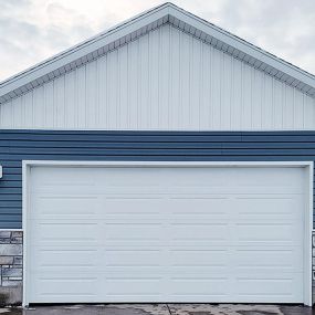 Newly installed white residential garage door, showcasing modern design and functionality.