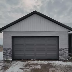 Modern gray double garage door installed in Riverdale, UT, by Beacon Garage Doors. Serving nearby cities like Hooper, West Haven, Marriott-Slaterville, and Washington Terrace, UT.