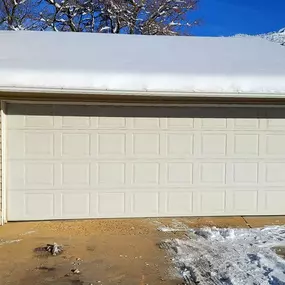 Newly installed white garage door in Sunset, Utah, with a winter backdrop. Professionally installed by Beacon Garage Doors to ensure durability, security, and smooth operation for homeowners.