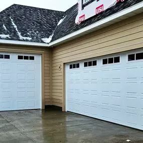 Newly installed white garage doors with decorative windows in South Ogden, Utah. Installed by Beacon Garage Doors for enhanced security, durability, and curb appeal.