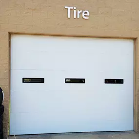 Commercial garage door installation in Weber County, Utah. Durable white sectional door with built-in windows, expertly installed by Beacon Garage Doors for enhanced functionality and security.