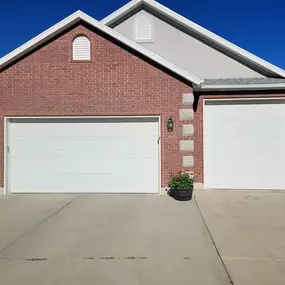 Twin white garage door installation in Clearfield, Utah. Professionally installed by Beacon Garage Doors, enhancing home security, durability, and curb appeal.