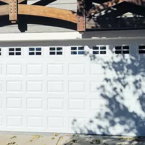 Newly installed white garage door with decorative windows in North Ogden, Utah. Professionally installed by Beacon Garage Doors, ensuring security, durability, and curb appeal for homeowners.