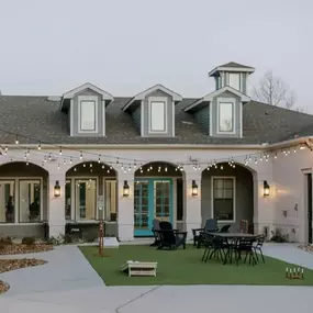 Outdoor gaming space including cornhole and ample seating.