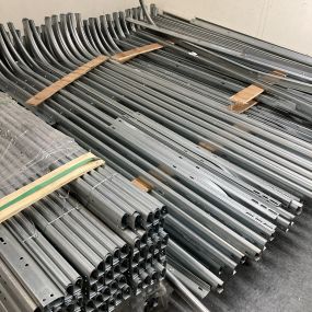 A picture of garage door rails stacked up on the floor
