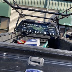 A picture Unlimited Garage Door Services work truck with some supplies in the bed