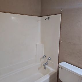 A picture of a bathroom with a toilet, tub and tile floor