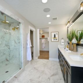 Elegant primary bathroom with dual-sink vanity and full tile shower