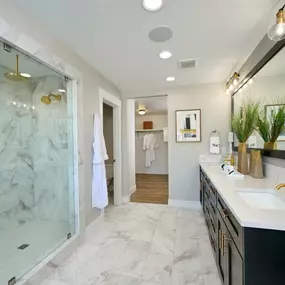 Elegant primary bathroom with dual-sink vanity and full tile shower