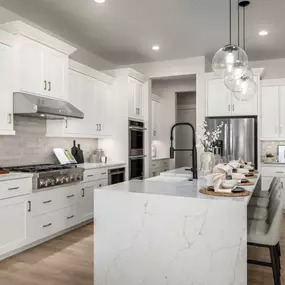 Chef inspired kitchens with gas ranges, large center islands, and abundant cabinet space