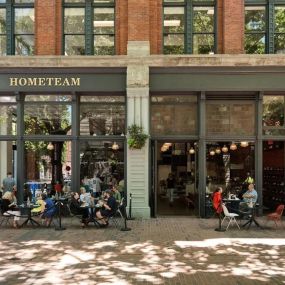 The inviting storefront of HOMETEAM SEATTLE, a premier sneaker store with limited edition sneakers and an indoor restaurant.