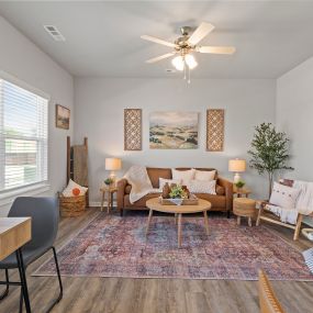 a living room with couches and a table and a ceiling fan