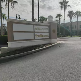 A big shopping center sign reading WING STOP & YOUFIT GYMS