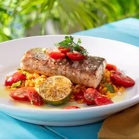 Jerk Mahi -Sauteed and topped with a fresh tomato salad, lime vinaigrette and served with yellow rice.