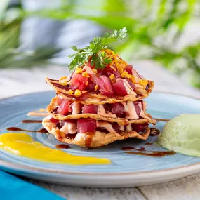 NEW! Tuna Tostada Stack - Ahi tuna poke layered with crispy tortillas, drizzled with a zesty lime aioli, served with avocado.