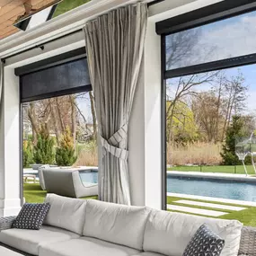 Prep your patio for cooler temps with layered outdoor solutions—elegant drapes paired with motorized shades for comfort, privacy, and style year-round.