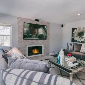 Cozy media room at the addiction recovery center with a fireplace, large TV, and comfortable seating. This inviting space is perfect for relaxation and enjoying therapeutic entertainment.