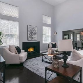 Luxury addiction treatment center living room featuring a cozy fireplace, modern furniture, and large windows that fill the space with natural light, creating a warm and inviting ambiance.