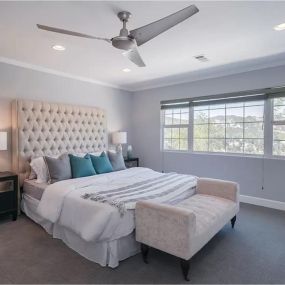 Modern Los Angeles drug and alcohol rehab bedroom featuring a tufted headboard, plush bedding, and large windows offering breathtaking scenic views. This luxurious bedroom design creates a peaceful retreat for clients undergoing addiction treatment.