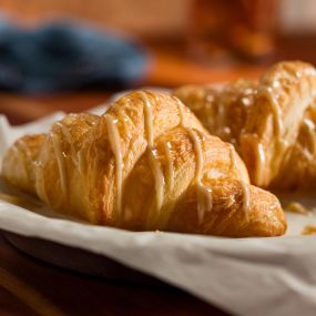 Honey Butter Croissants: Baked to a golden brown and drizzled with house-made honey butter.