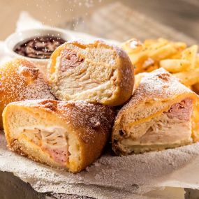 Monte Cristo: Smoked ham, smoked turkey, two cheeses, battered and fried until golden, with raspberry preserves and dusted with powdered sugar. Served with fries.