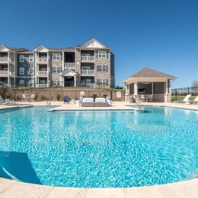 a swimming pool with an apartment building in the background