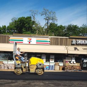 Dominion Paving Contractor smoothing out new layer of freshly paved asphalt at a job site