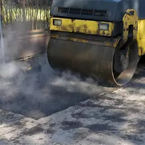 Asphalt Compactor Rolling Over a Fresh Layer of Asphalt