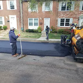 Dominion Paving Employees working together to lay down new asphalt at a job site