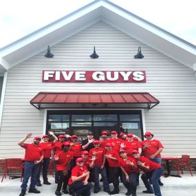 Employees pose for a photograph ahead of the grand opening of the Five Guys restaurant in Haymarket, Virginia.