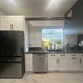 A clean and modern kitchen renovation with white cabinets, sleek stainless steel appliances, and updated lighting fixtures. This remodel enhances both style and usability, making the space feel open, bright, and thoughtfully designed.