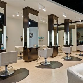 Our salon features beautiful tall mirrors with 12 spacious stations and chairs, providing ample room for bridal parties and events. Enjoy a luxurious and comfortable experience in our elegantly designed space.